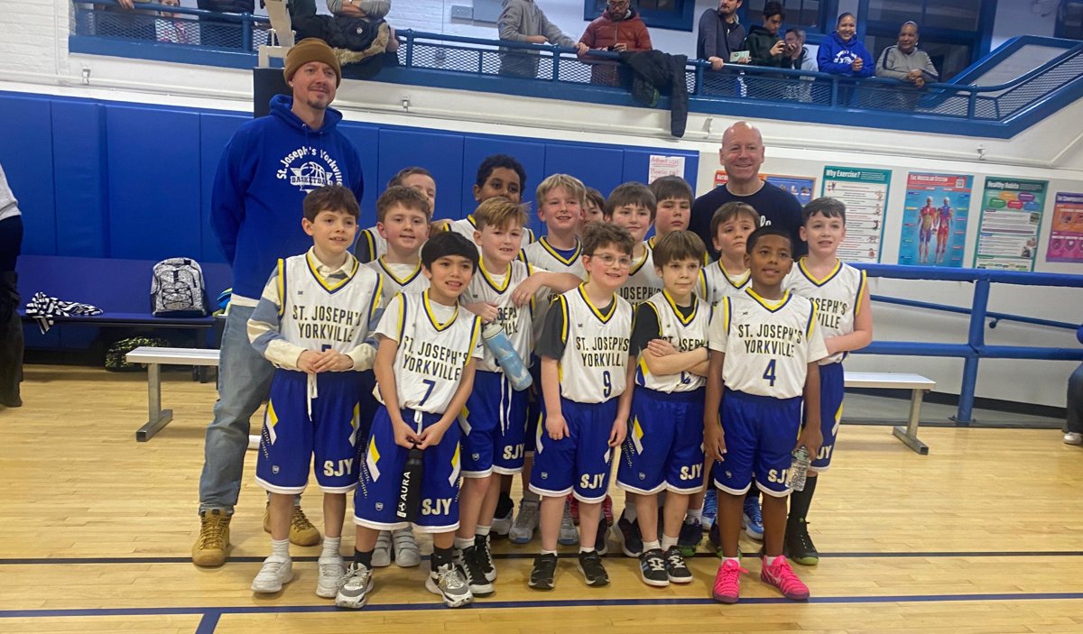 A St. Joseph's Yorkville boys basketball team posing together after a game.