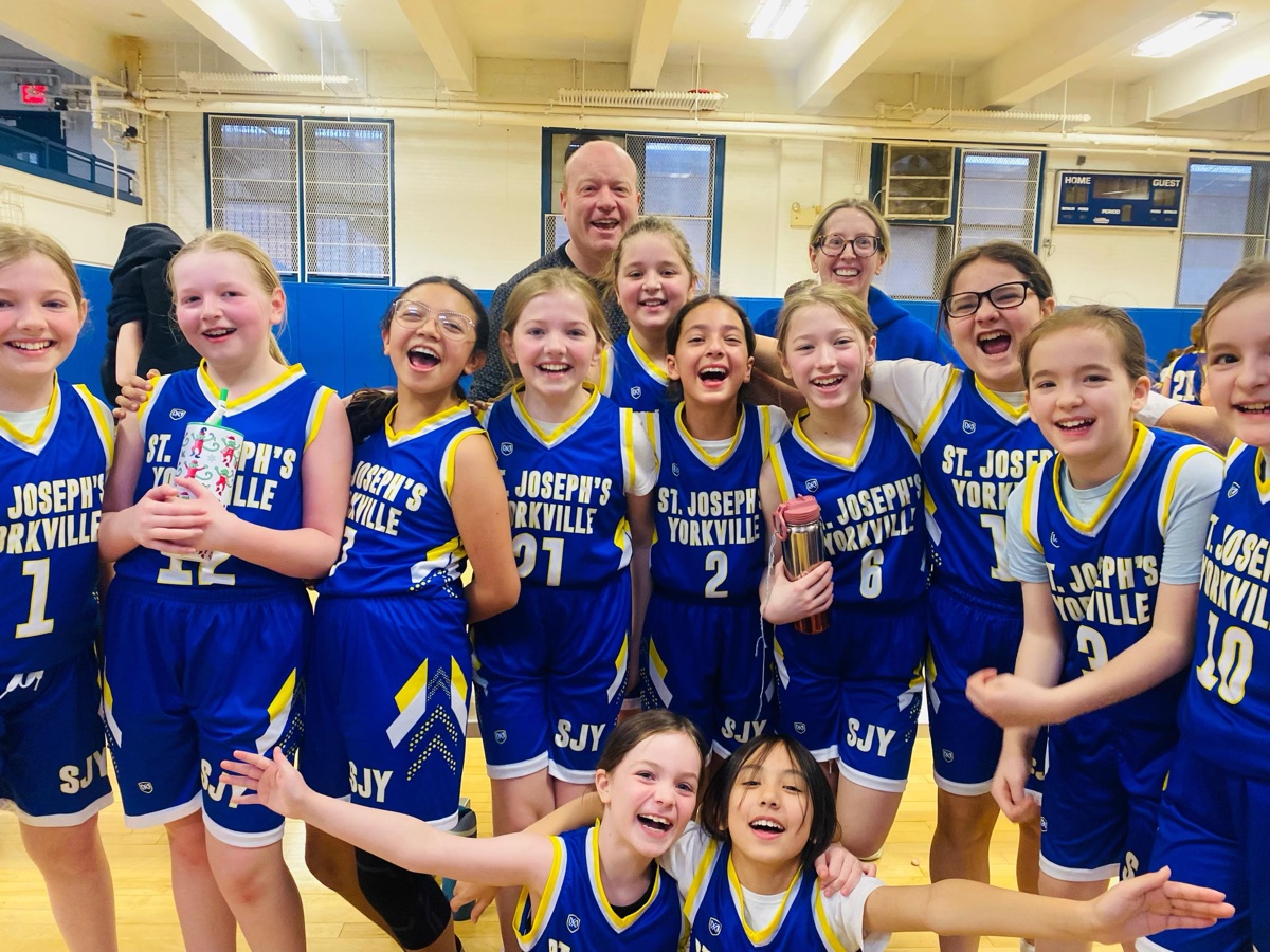 A St. Joseph's Yorkville girls basketball team celebrating together after a win.